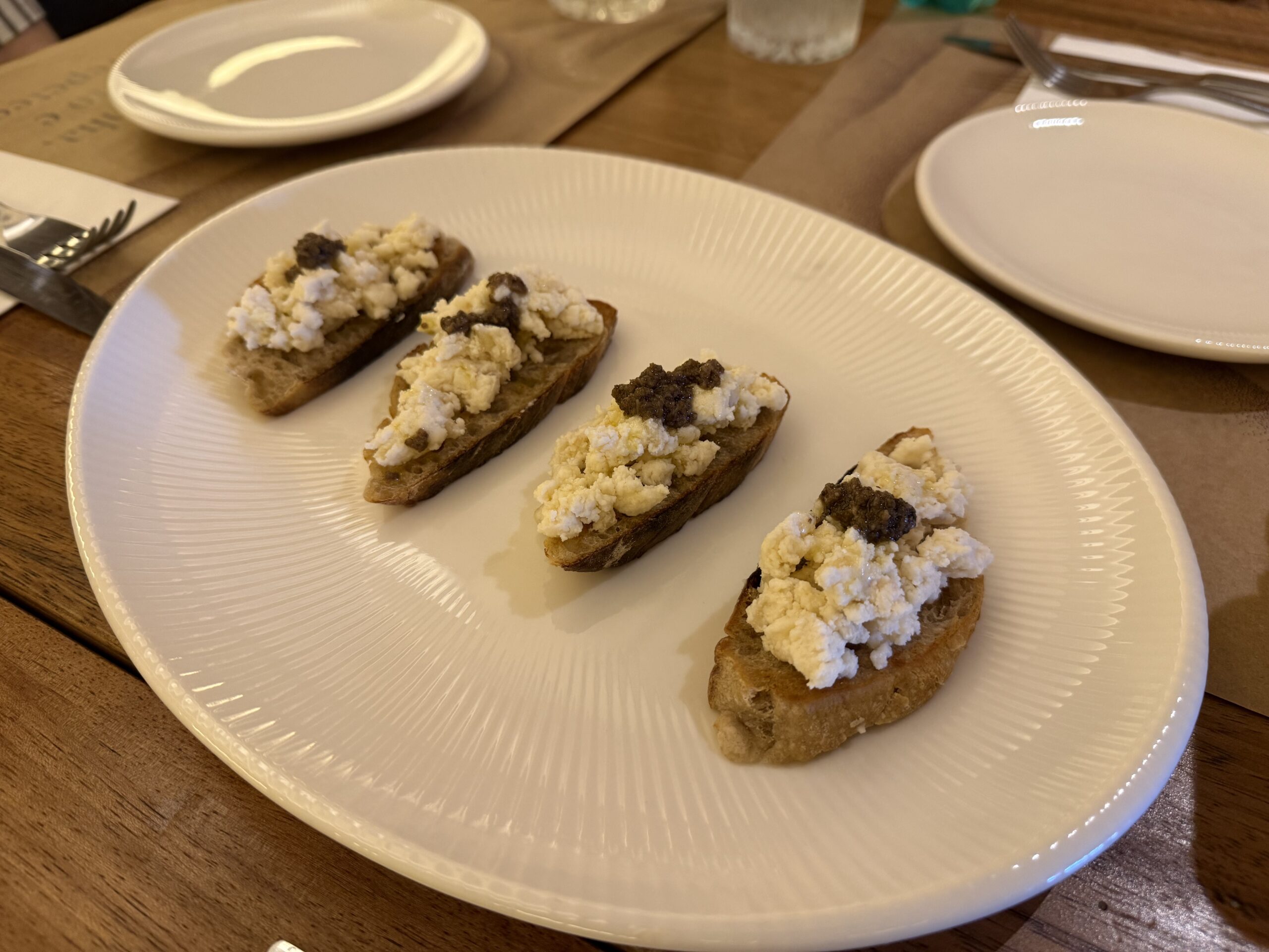 Bruschetta de queijo tulha, pera e mel do Taglia