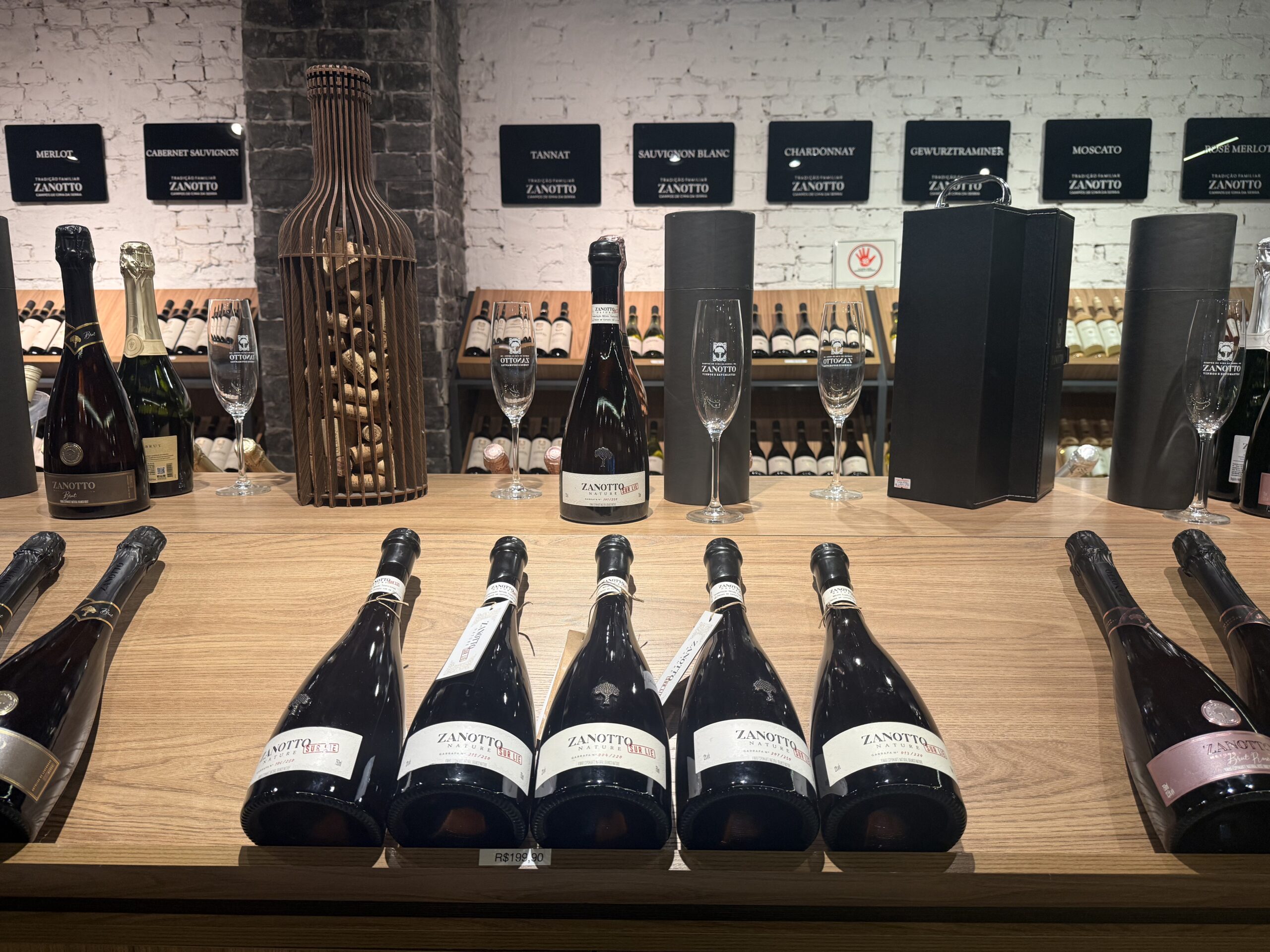 Vinhos Zanotto com taças e garrafas espalhadas na mesa do rodízio